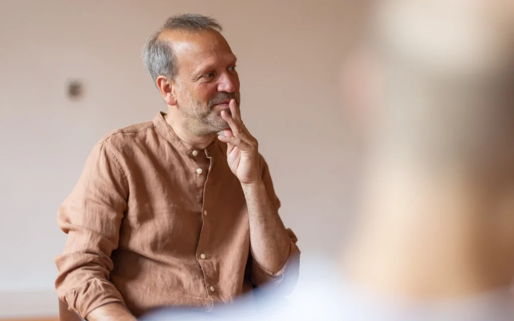 Systemischer Coach aus Hamburg hört einem Klienten konzentriert zu